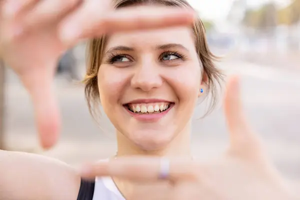 stock image Smiling happy young woman gesturing frame with hands, smiling and looking away - Portrait of beautiful caucasian woman enjoying a day out in Barcelona