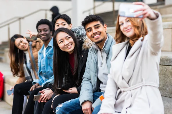 Multiracial people taking a selfie together and making funny faces - Happy friendship and diversity concepts with mixed race young best friends having fun in the city
