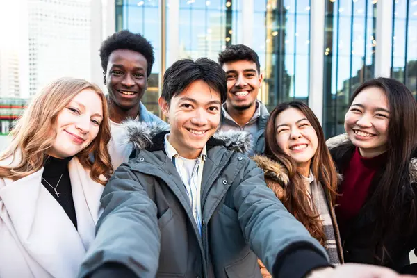 Multiracial people taking a selfie together and making funny faces - Happy friendship and diversity concepts with mixed race young best friends having fun in the city