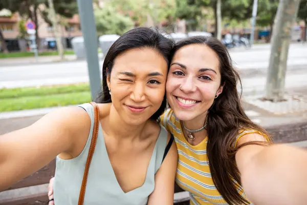 2人の女性の親友が抱擁し セルフィーを取る バルセロナで一緒にコーカサスとアジアの女性 多文化都市と現実の人々とのコンセプトを愛する ストック写真