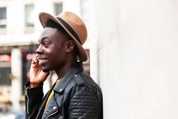 電話で話す幸せな黒人男性と笑顔 ロンドンのファッションの若者が電話で会話を楽しむ ライフスタイル コミュニケーションの概念 ストック写真