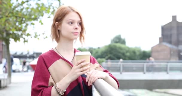 一个沉思的年轻女子在户外喝咖啡的真实镜头 一个女人在室外休息和陷入沉思的画像 — 图库视频影像