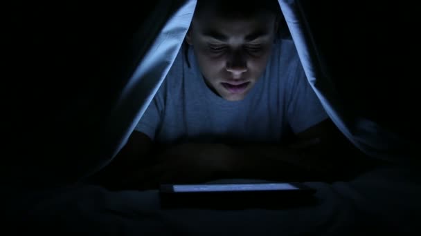 看恐怖片数字平板电脑在床单下的女人 — 图库视频影像