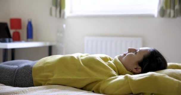 真正拍摄的快乐女人躺在床上 享受美好的一天 家里的生活方式和放松的概念 — 图库视频影像