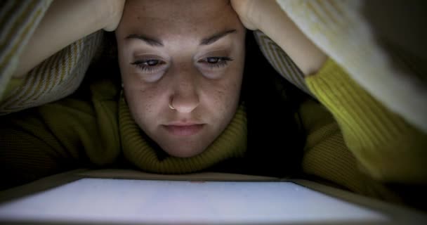 ブランケットの下にベッドに泊まり デジタルタブレットで勉強する女性 ライフスタイルと技術のコンセプト — ストック動画