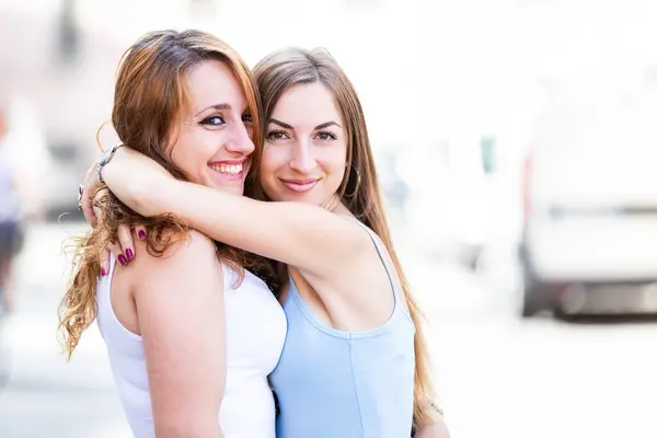 Mujeres Felices Ciudad Sonriendo Abrazándose Dos Mujeres Jóvenes Caucásicas Divirtiéndose Fotos de stock libres de derechos