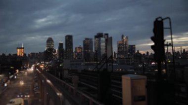 New York 'un gece görüşü metro treni ve ön planda arabalar ve arka planda gökdelenler - New York' ta seyahat ve mimari kavramlar
