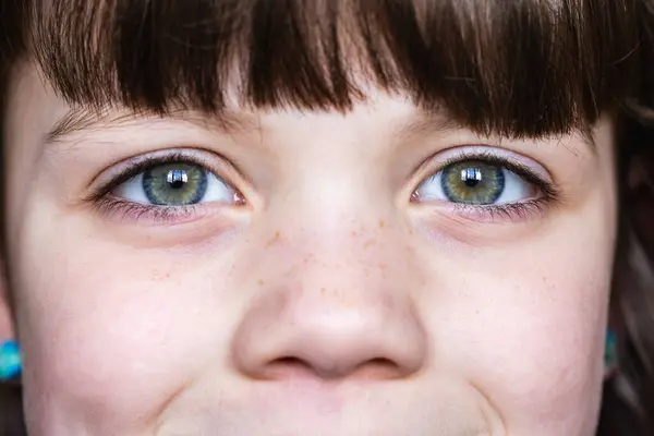 マクロショット 若い子供の緑色の目をキャプチャし 素晴らしい詳細と明快さでフリック 表情豊かな目で子供のフリックされた顔のクローズアップ ストック画像