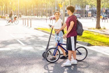 Barcelona 'daki mutlu çift bisiklet ve scooterla denize gidiyor gülen adam ve kadın yürüyor, bisiklet sürüyor ve elektrikli scooter sürüyor yaşam tarzı, seyahat ve aşk kavramları, İspanya' da sıcak bir yaz günü