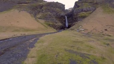İzlanda 'daki şelale manzarası, arka planda karlı dağlar, İzlanda' nın güneyinde güzel şelale, insansız hava aracı manzarası, seyahat ve doğa kavramları.