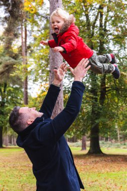 Baba, neşeli bir sonbahar ormanında oğlunu kaldırır, düşen yaprakların arasında neşeyle havaya fırlatır, aile bağlarını ve çocukluk neşesini açık havada yakalar.