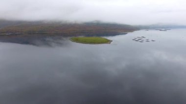 Aerial drone view of Loch Leven in Scotland on a moody misty day, with low clouds over the mountains and the water - Nature and travel with moody weather in Scottish highlands