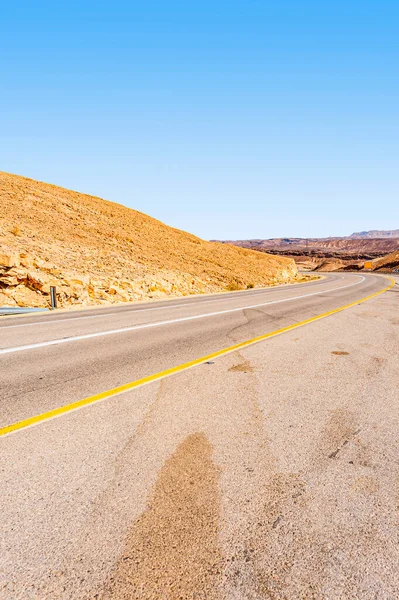 イスラエルのネゲヴ砂漠の砂の丘を通るアスファルトの道路 ロイヤリティフリーのストック画像