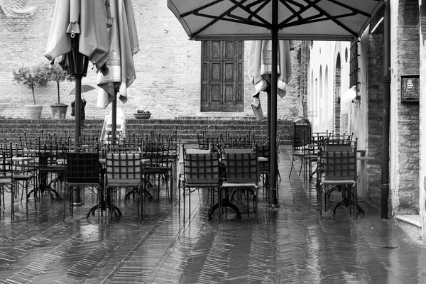 黒と白の観光客の不在でイタリアの都市Montepulcianoの雨の日の屋外カフェ ストック画像