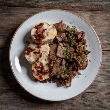 Saute Ciğer Ekmek Hamur köftesiyle servis edilir üstüne de gevrek domuz eti.