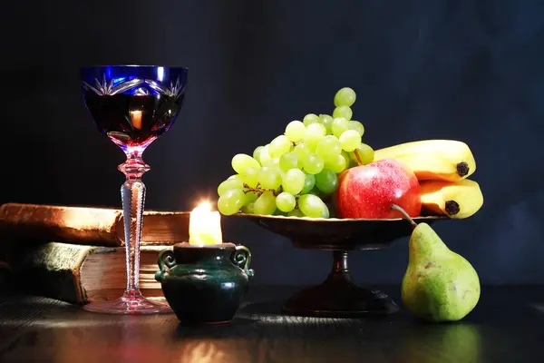 キャンドルやフルーツの近くにワイングラスと素晴らしいヴィンテージの静かな生活 ストック写真
