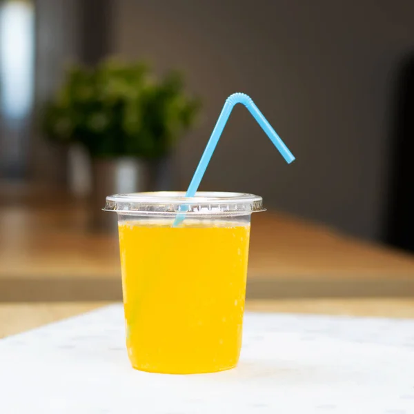 Copa Plástico Con Bebida Naranja Paja Mesa Cafetería —  Fotos de Stock