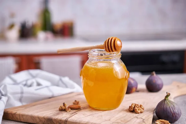 台所のテーブルの上のガラス瓶や鍋で蜂蜜 — ストック写真