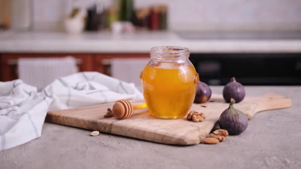 台所のテーブルの上のガラス瓶や鍋で蜂蜜 — ストック動画