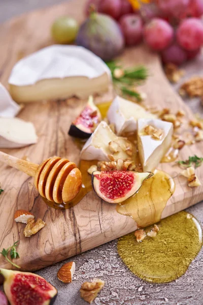 国産キッチンで木製のまな板にカンバートやブリーチーズをスライス — ストック写真