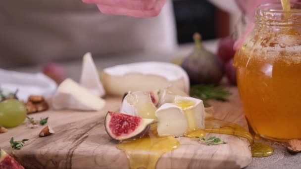 Kobieta Wylewa Miód Plasterki Sera Camembert Lub Brie Deskę Krojenia — Wideo stockowe