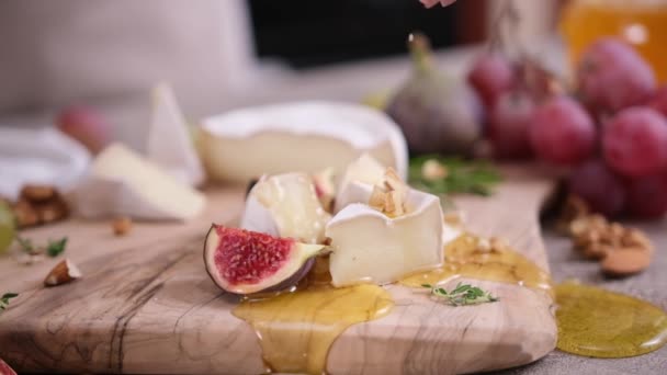 Kobieta Wylewa Orzechy Włoskie Plasterki Sera Camembert Lub Brie Deskę — Wideo stockowe