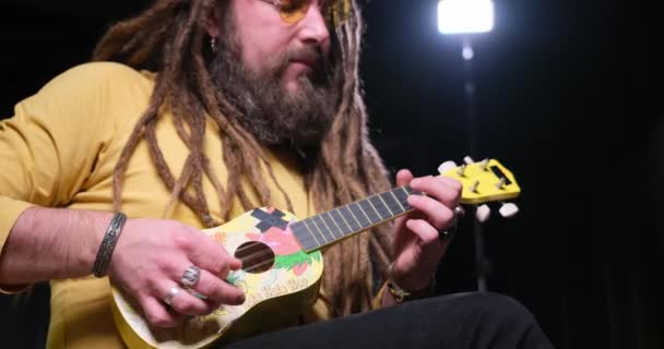 Guitarist Man Plays Ukulele Guitar Close Studio — Vídeos de Stock
