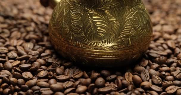 Stalen Cezve Omgeven Door Gebrande Koffiebonen Een Roterende Achtergrond — Stockvideo