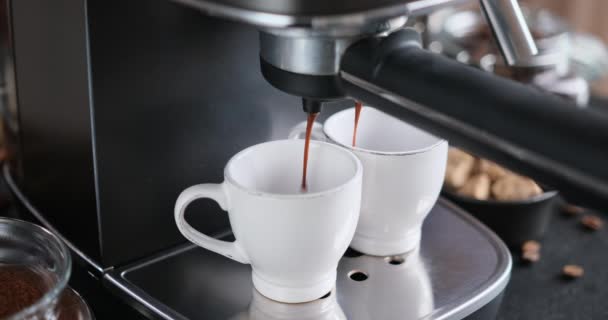 에스프레소 가정에서 만드는 기계에서 세라믹 컵으로 흘러드는 커피의 — 비디오