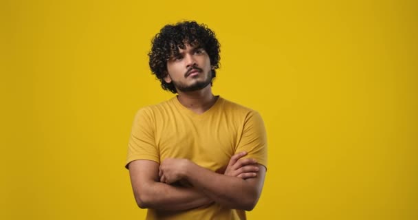 若いインド人男性がスタジオの背景の上に立って顎の近くに手で考えている Dci 二重スローモーション — ストック動画