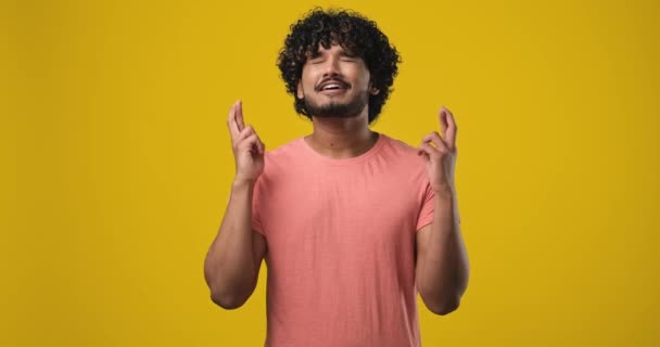 年轻英俊的印度男子 身穿T恤衫 手握手指 祈求好运向上看 Dci 2X慢动作 — 图库视频影像