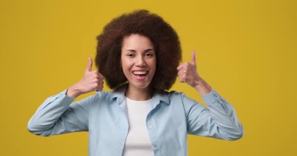 年轻的非洲裔美国女人带着大拇指对着孤立的黄色背景笑着 Dci 2X慢动作 — 图库视频影像
