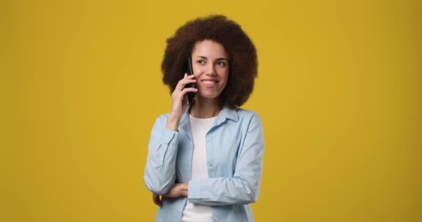 年轻美丽的微笑的非洲裔美国女人在电话里通过黄色的橙色背景接听电话 Dci 2X慢动作 — 图库视频影像