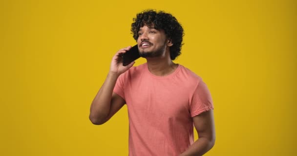 Jovem Índio Sorridente Falando Telefone Respondendo Telefonema Sobre Fundo Laranja — Vídeo de Stock