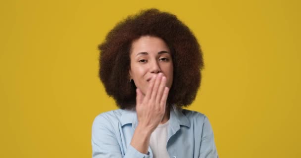 年轻的非洲裔美国女人带着自信的微笑亲吻孤立的橙色工作室背景 Dci 2X慢动作 — 图库视频影像