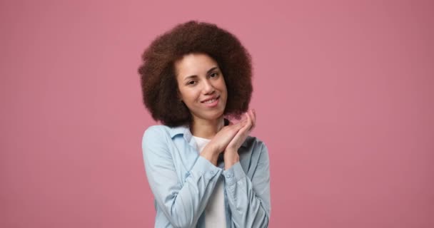 微笑迷人的非洲裔美国女人 卷曲的头发凝视着站在粉色背景上的相机 Dci 2X慢动作 — 图库视频影像