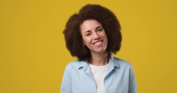 オレンジ色のスタジオの背景の上に立つ魅力的なアフリカ系アメリカ人女性を笑顔 Dci 二重スローモーション — ストック動画