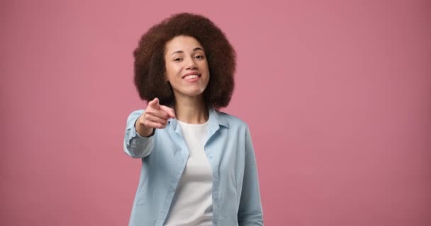 年轻的非洲裔美国女人直接看着摄像机 在粉色的工作室背景上竖起大拇指 看起来很开心 Dci 2X慢动作 — 图库视频影像