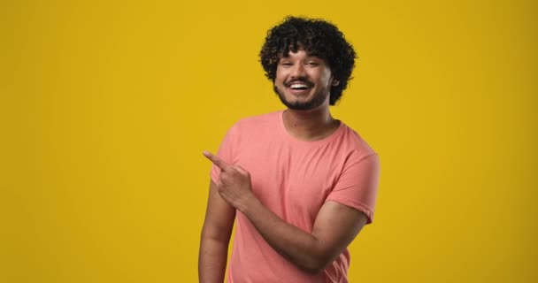 Εντυπωσιασμένος Χαμογελαστός Νεαρός Ινδός Που Δείχνει Δείκτη Στο Πλάι Κενό — Αρχείο Βίντεο