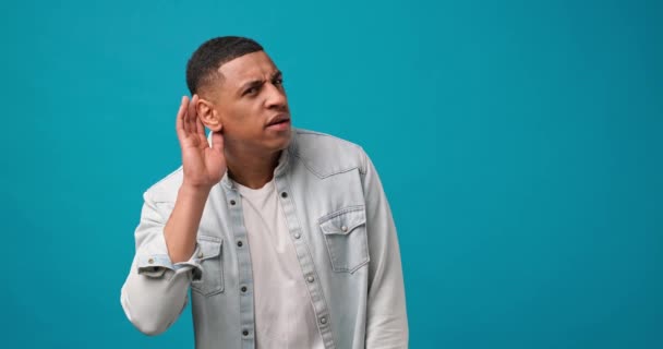 Nyfiken Förvånad Afroamerikansk Man Håller Handen Nära Örat Och Försöker — Stockvideo