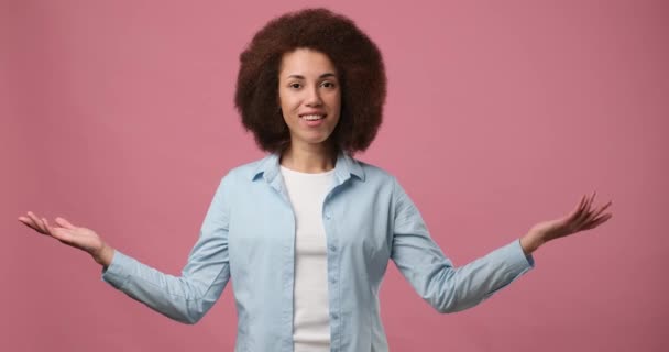 ピンクのスタジオを背景に孤立した手で広告や製品の配置のための空のモックアップスペースに脇を示す若いアフリカ系アメリカ人女性 Dci 二重スローモーション — ストック動画