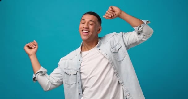 青のスタジオで踊る若いアフリカ系アメリカ人の幸せな男 Dci 二重スローモーション — ストック動画