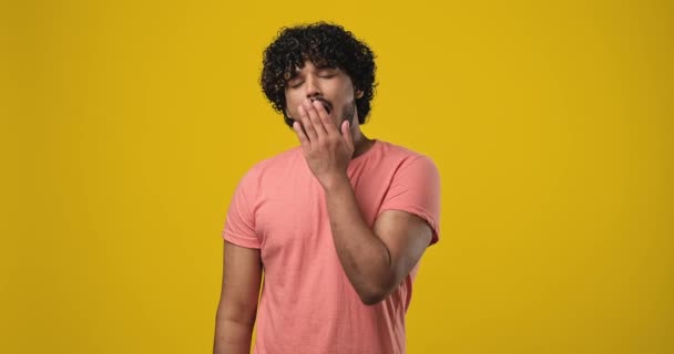 Unatkozó Kimerült Fiatal Indián Férfi Ásít Sárga Stúdió Háttere Fölött — Stock videók