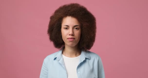 真剣な若いアフリカ系アメリカ人女性が何かを聞いて確認し 頭がピンクのスタジオの背景に隔離された受け入れで肯定的な応答を与えます Dci 二重スローモーション — ストック動画