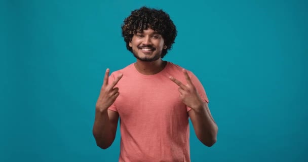 Cheerful Indian Guy Gesturing Sign Smiling Standing Isolated Blue Studio — Stock Video