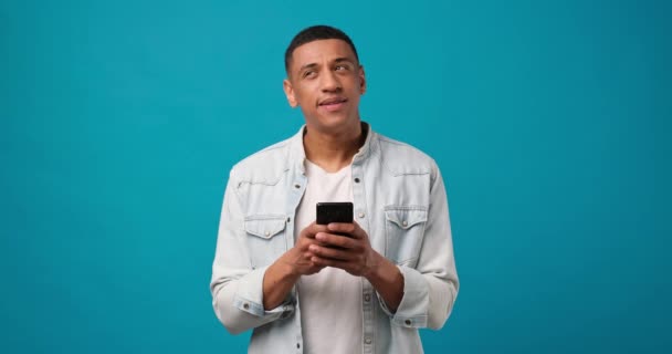 Giovane Uomo Afroamericano Pensoso Sorridente Utilizzando Cellulare Digitando Sms Messaggio — Video Stock