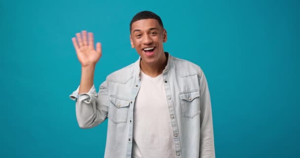 Young African American Man Waves Hand Palm Hello Gesture Welcomes — Stock Video