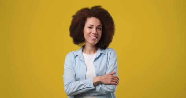 年轻微笑的非洲裔美国女人挥手告别 站在橙色工作室的背景下 Dci 2X慢动作 — 图库视频影像
