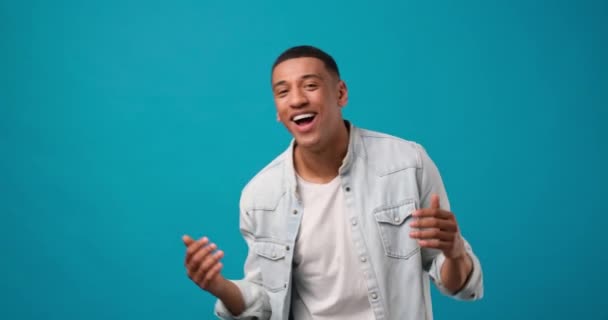 青のスタジオで踊る若いアフリカ系アメリカ人の幸せな男 Dci 二重スローモーション — ストック動画