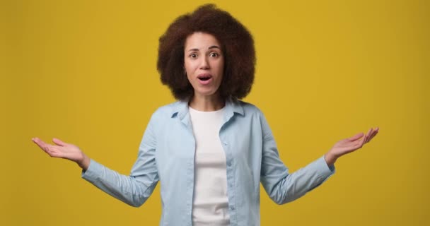 快乐的非洲裔美国女人在空旷的广告区指指点迷津 想在橙色工作室背景下找到一个商业广告的地方 Dci 2X慢动作 — 图库视频影像
